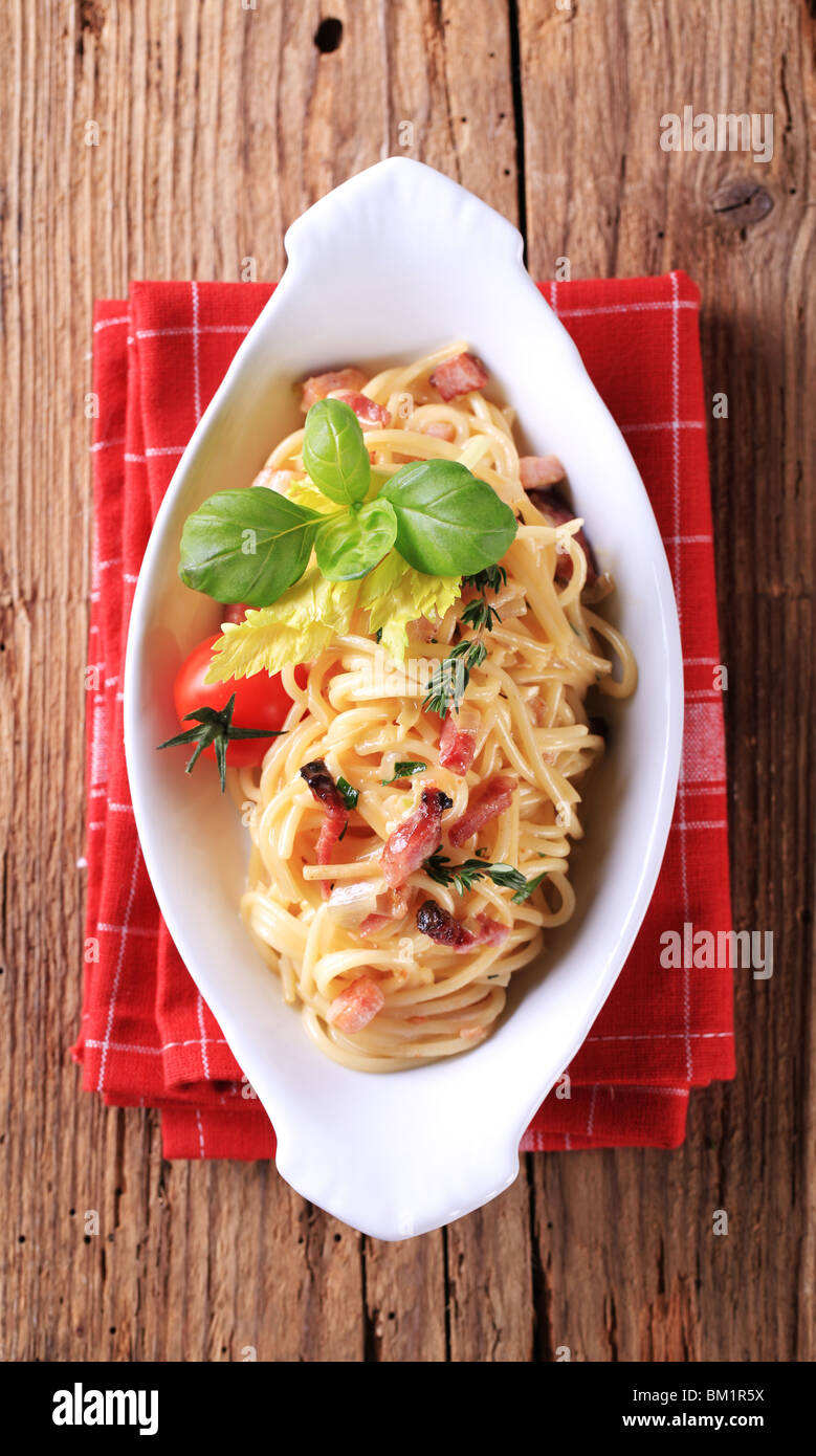 Plato de espagueti con tocino, cebolla y huevo Foto de stock