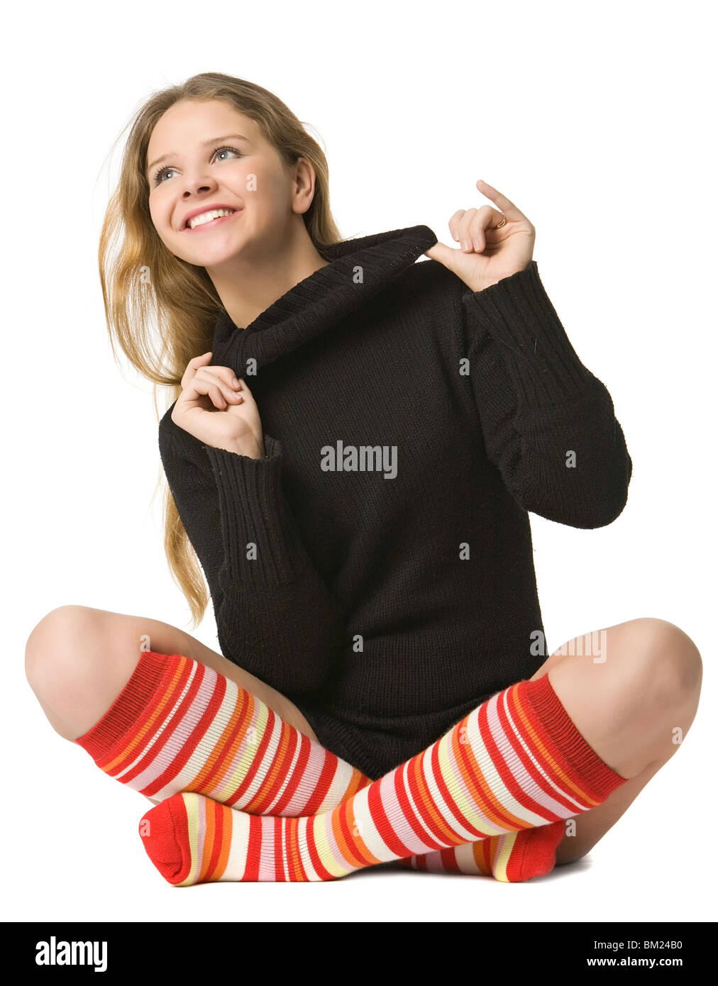 Hermosa niña en marrón suéter y en rayas calcetines largos sentarse en el  piso, aislado en blanco Fotografía de stock - Alamy