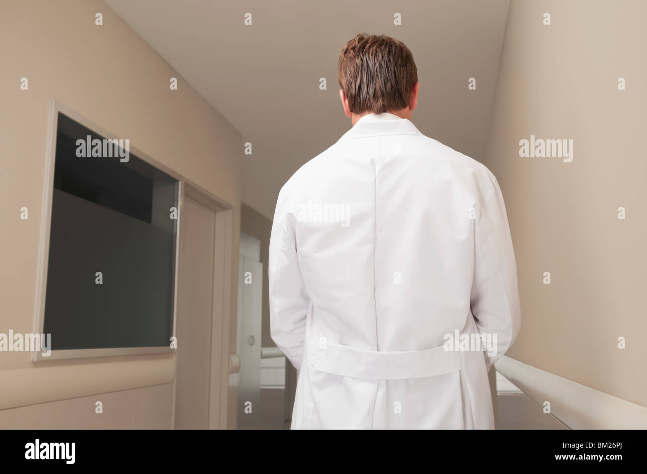 Vista trasera de un doctor de pie en el pasillo Foto de stock