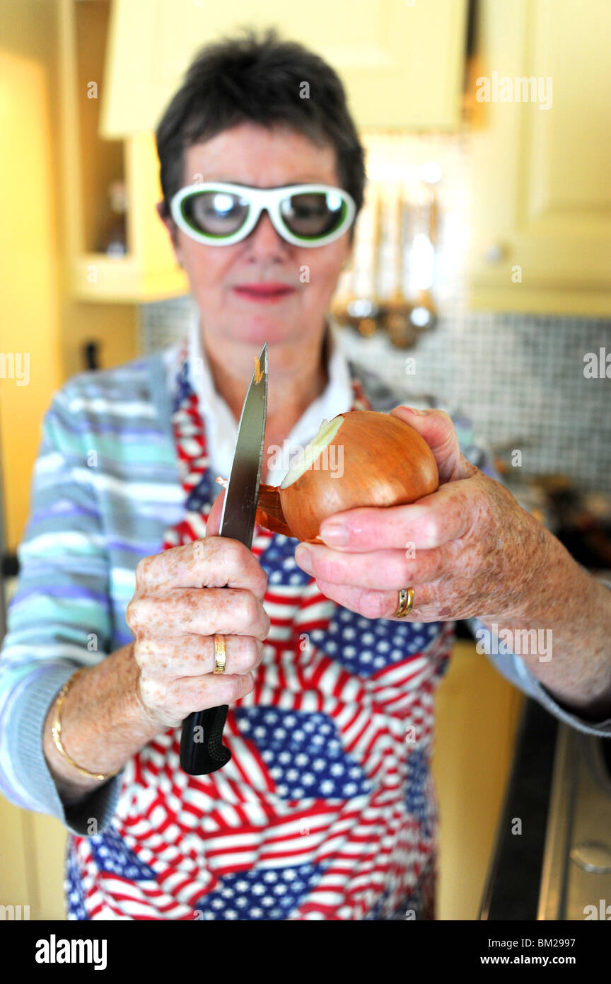 Mujer preparando y pelar la cebolla con unas gafas especiales para detener  el riego de los ojos Fotografía de stock - Alamy