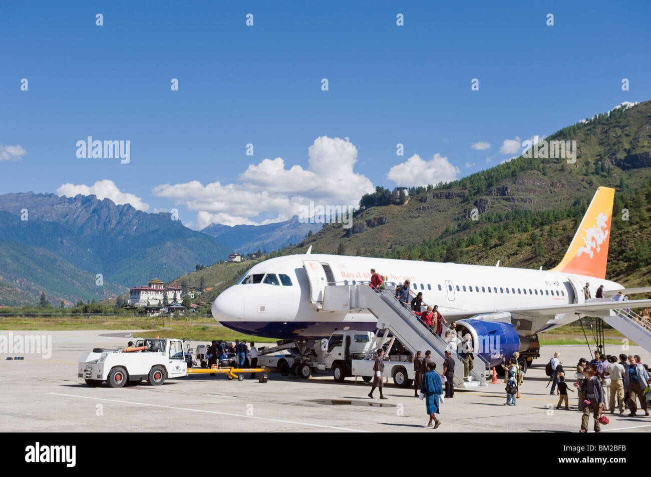 Avión de pasajeros en el Aeropuerto Internacional de Paro, Paro Rinpung Dzong en la distancia, Paro, Bhután, Himalaya Foto de stock