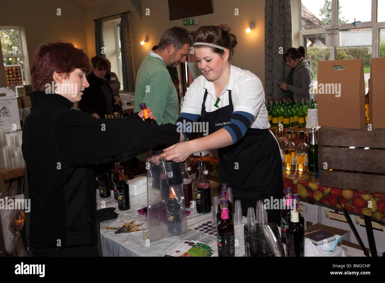 Reino Unido, Inglaterra, Herefordshire, Putley, Gran Evento Apple, Pixley bayas productos stallholder vender botellas de jugo de frutas Foto de stock