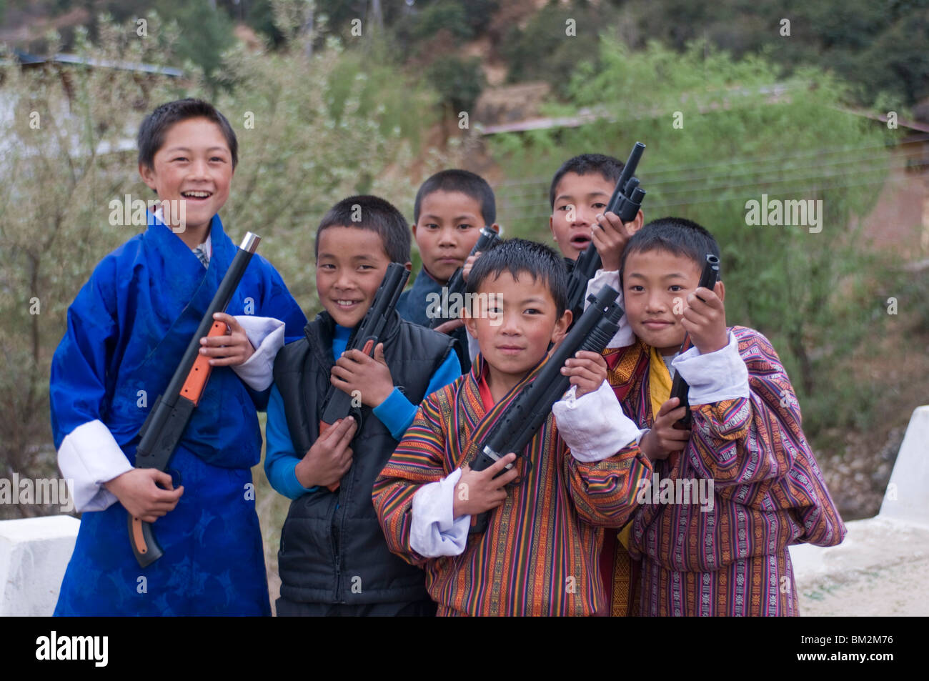 Jóvenes de Bhután muchachos jugando con sus pistolas de juguete, Paro, Bhután Foto de stock