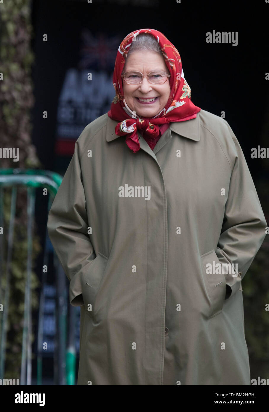 La Reina Isabel II de Gran Bretaña llevaba un impermeable y pañuelo rojo en el Royal Windsor Horse Show Foto de stock