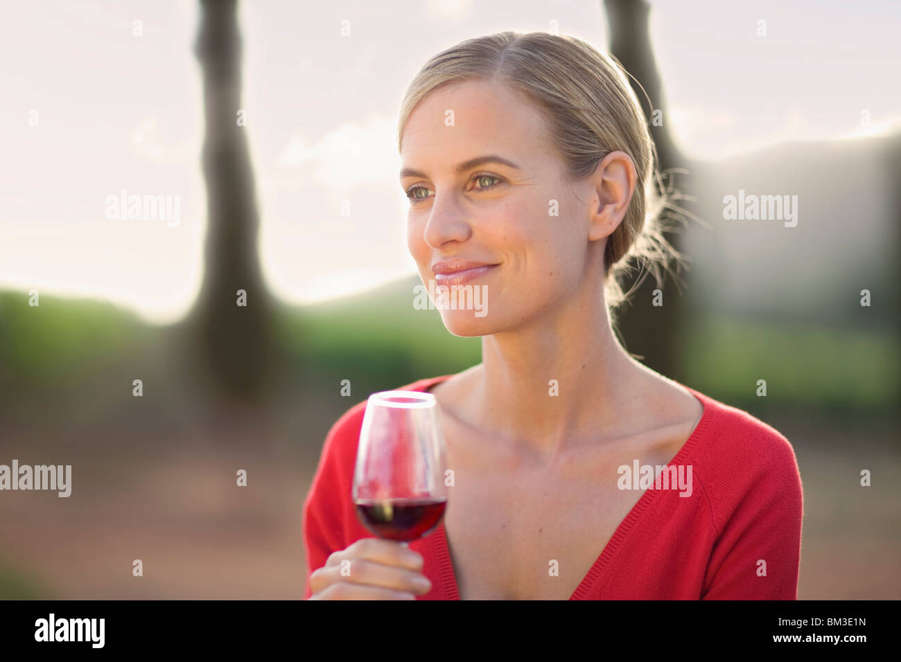 La mujer disfruta de una copa de vino tinto Foto de stock
