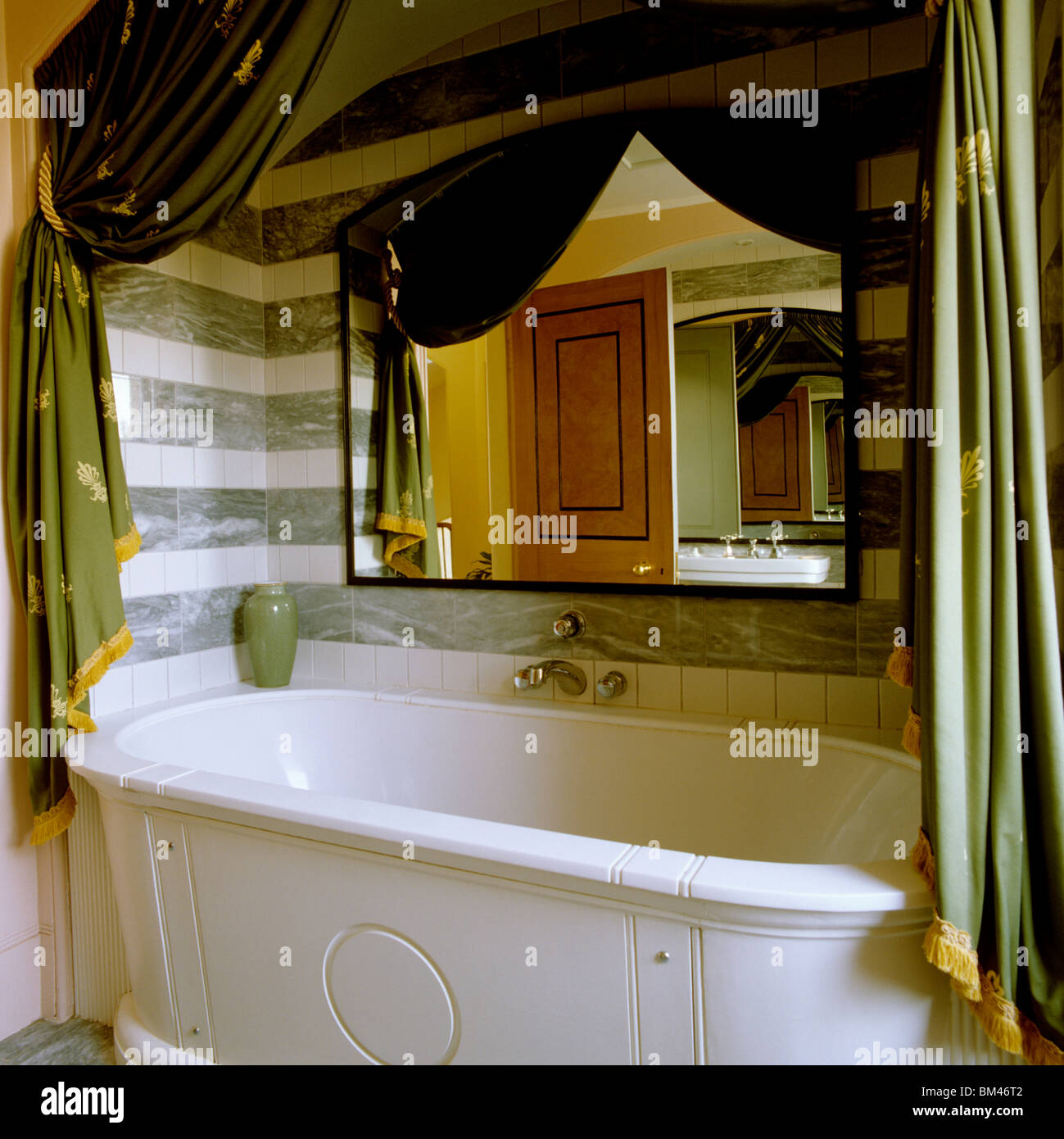 Bañera en la alcoba con cortinas de estilo neoclásico Foto de stock