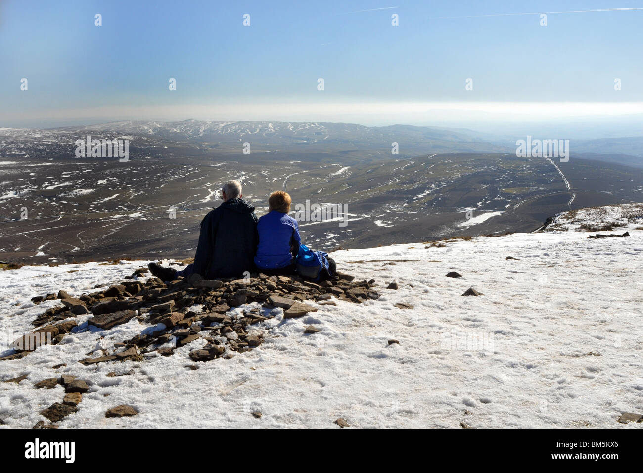 Una pareja madura mirada en los nevados paisajes que rodean a lápiz y Gante Yorkshire Dales National Park Foto de stock