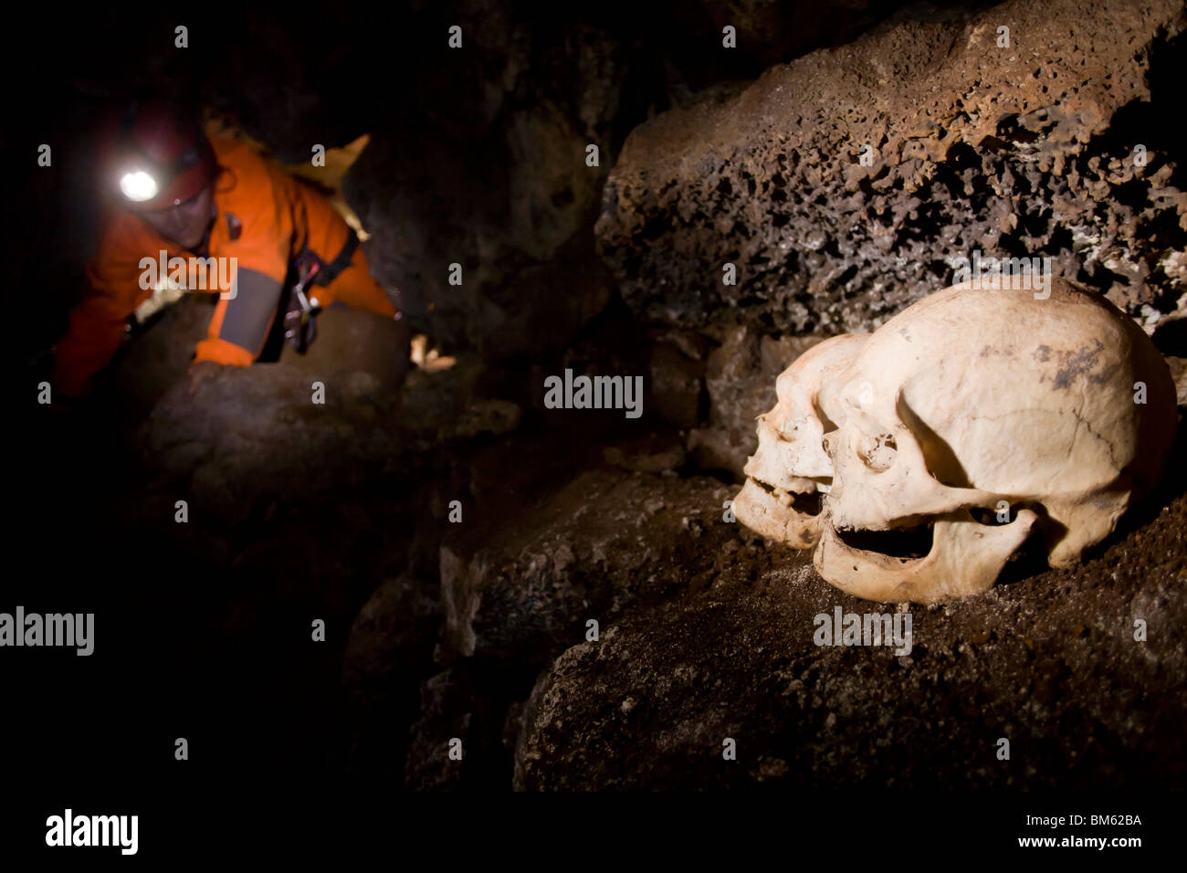 Caver arrastrándose junto a cráneos enterrados en la cueva Ana Vaiteka en  Rapa Nui Isla de Pascua Isla de Pascua Chile pacífico Fotografía de stock -  Alamy