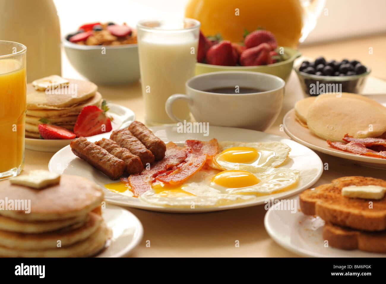 Desayuno, salchicha, tocino, huevos, tostadas, café, cereales, fruta, tostadas y tortitas Foto de stock