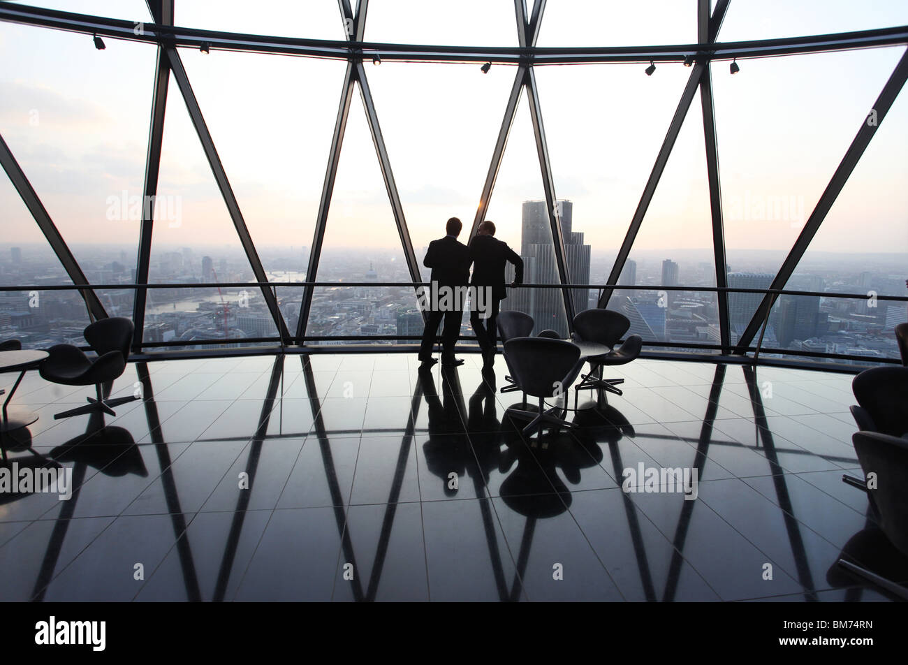 Los empresarios stand y charla en la parte superior del pepinillo rascacielos en la ciudad de Londres, Reino Unido. Foto de stock