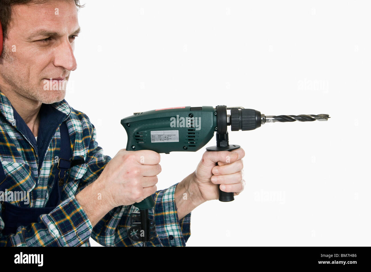 Un trabajador de la construcción con un taladro Foto de stock