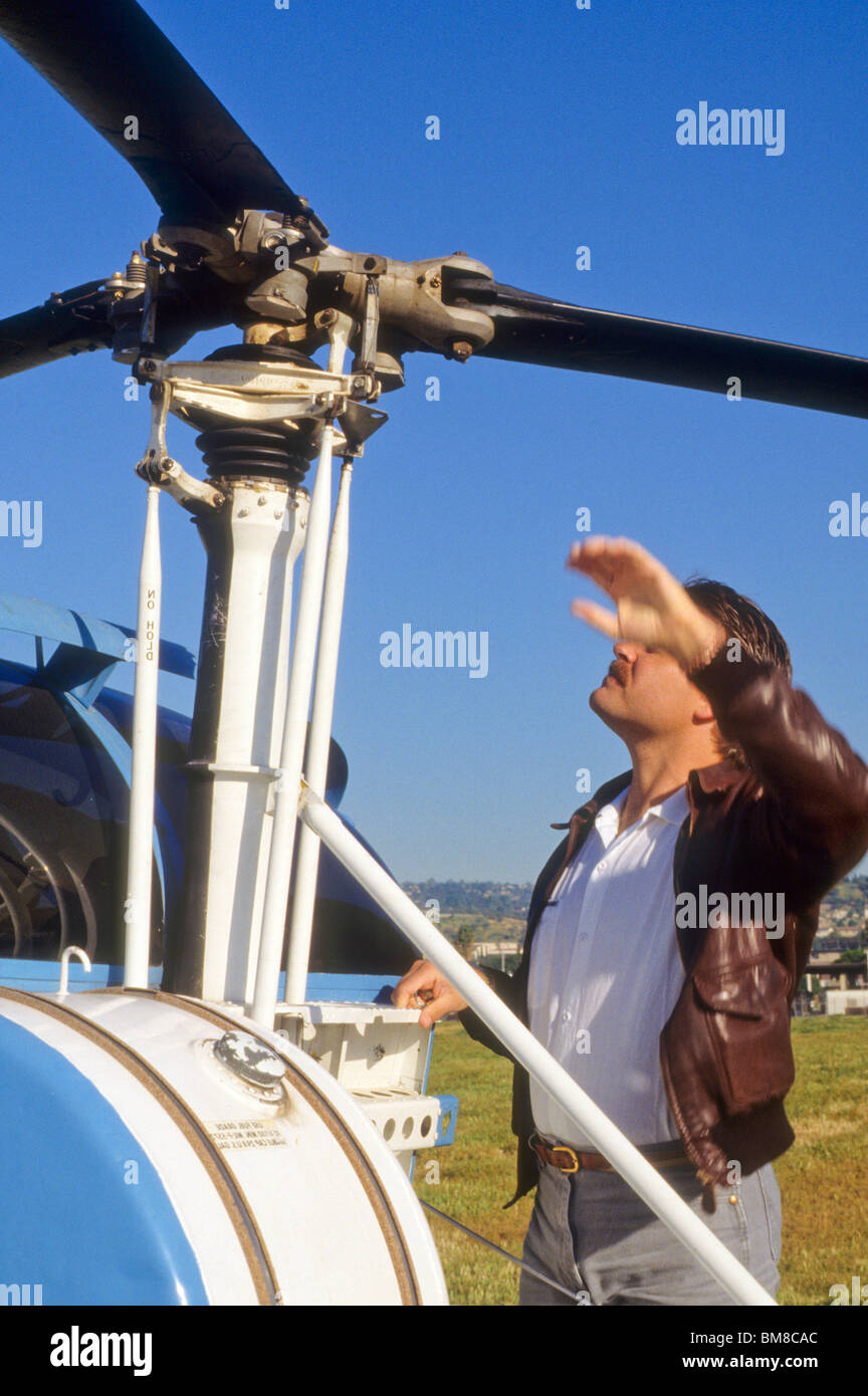 Piloto de helicóptero rotor comprobaciones de su avión antes de inspeccionar el picador de vuelo seguro Foto de stock