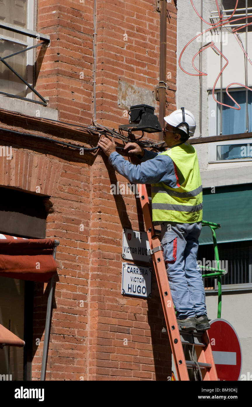 Intermedio borde Zoológico de noche Electricista en la parte superior de una escalera realiza un trabajo de  reparación en el centro de Toulouse Fotografía de stock - Alamy