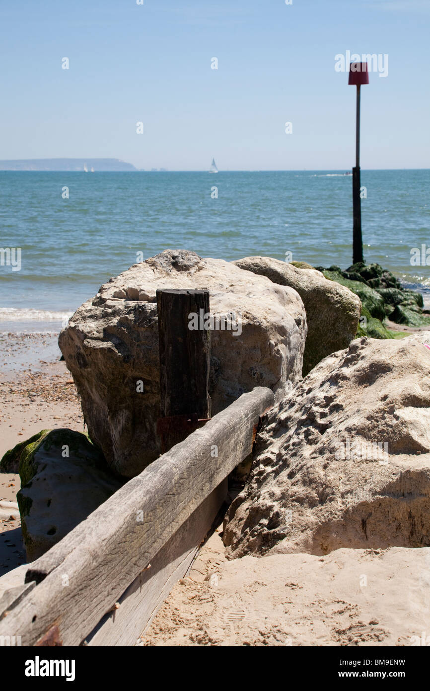 Espigón de piedra y madera con marcador encuesta sobre Playa de Mudeford Foto de stock