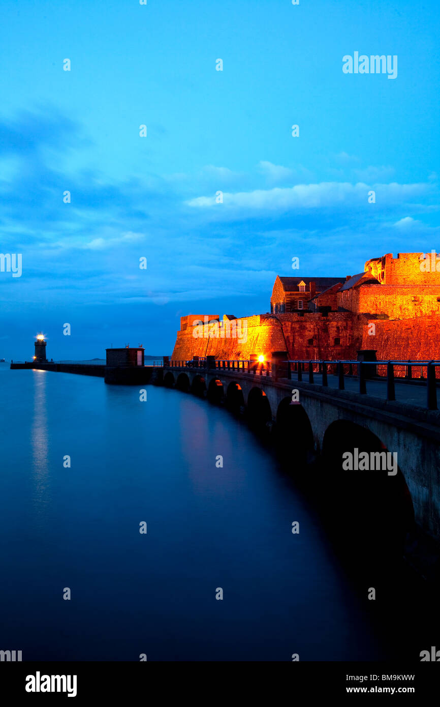 Castillo Cornet al anochecer, mostrando una impresionante iluminación, Guernesey, Canal, Reino Unido. Foto de stock