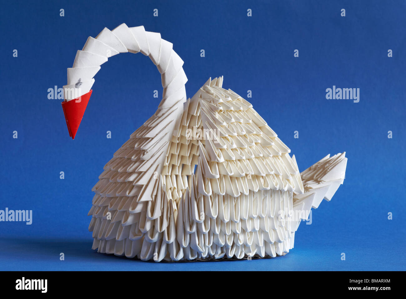 Origami swan aislado sobre fondo azul - el arte de doblar el papel  Fotografía de stock - Alamy