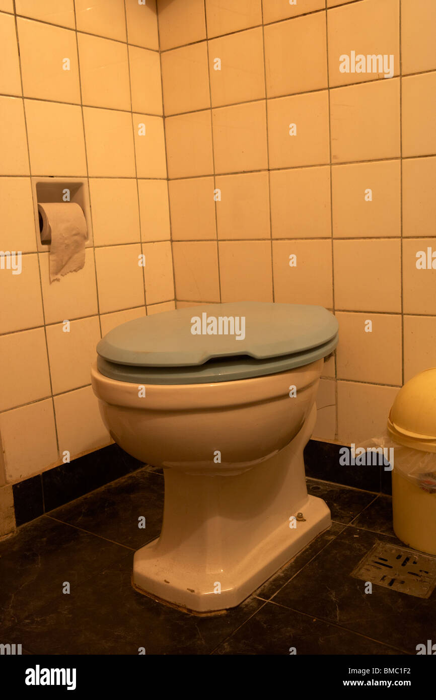 Asiento de inodoro abajo en el baño con luz liberada de propiedad imagen no  corregida Fotografía de stock - Alamy