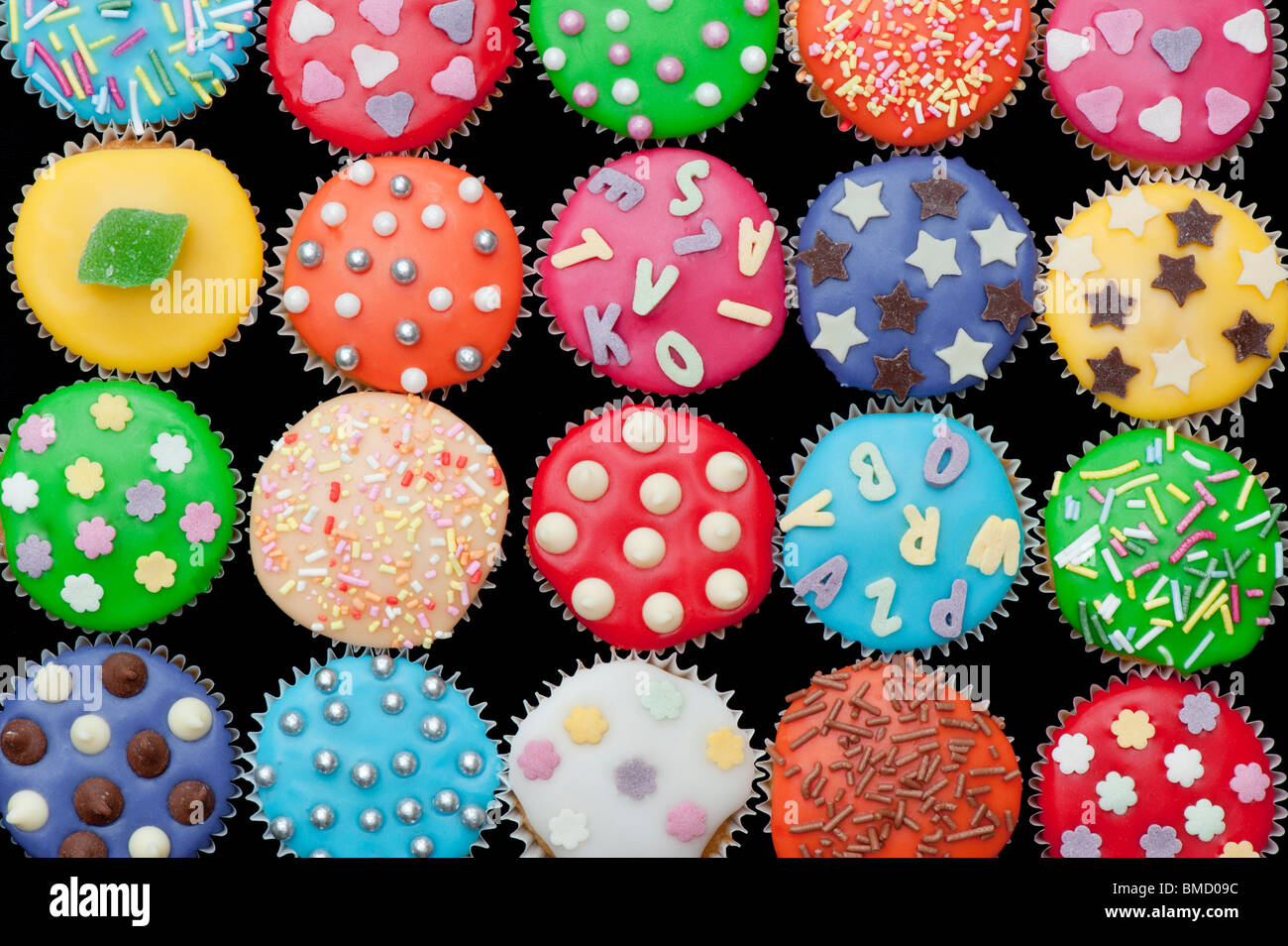 Colorido mini cupcakes sobre un fondo negro Foto de stock