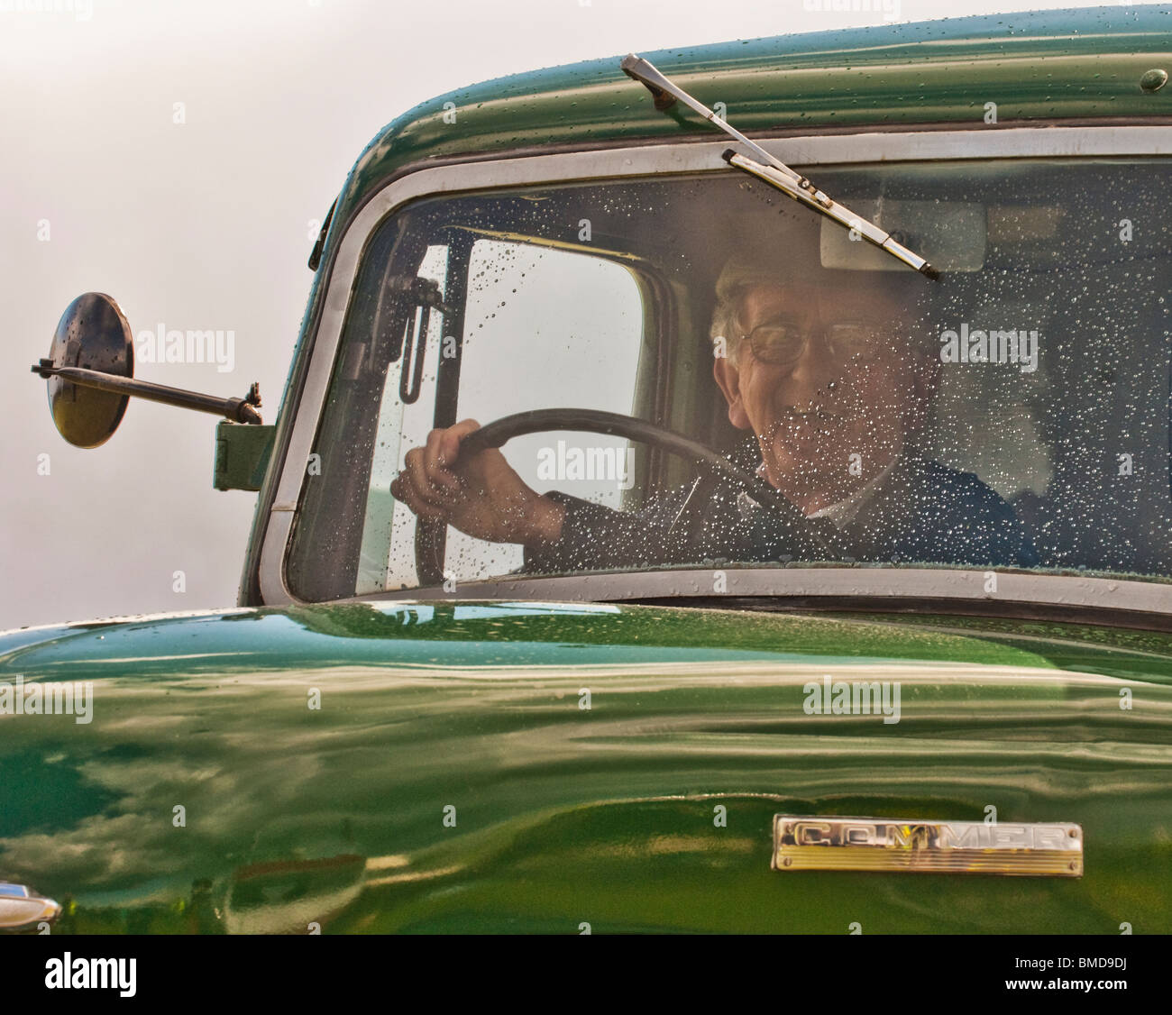 Viejo hombre que conducía un viejo camión vintage Foto de stock