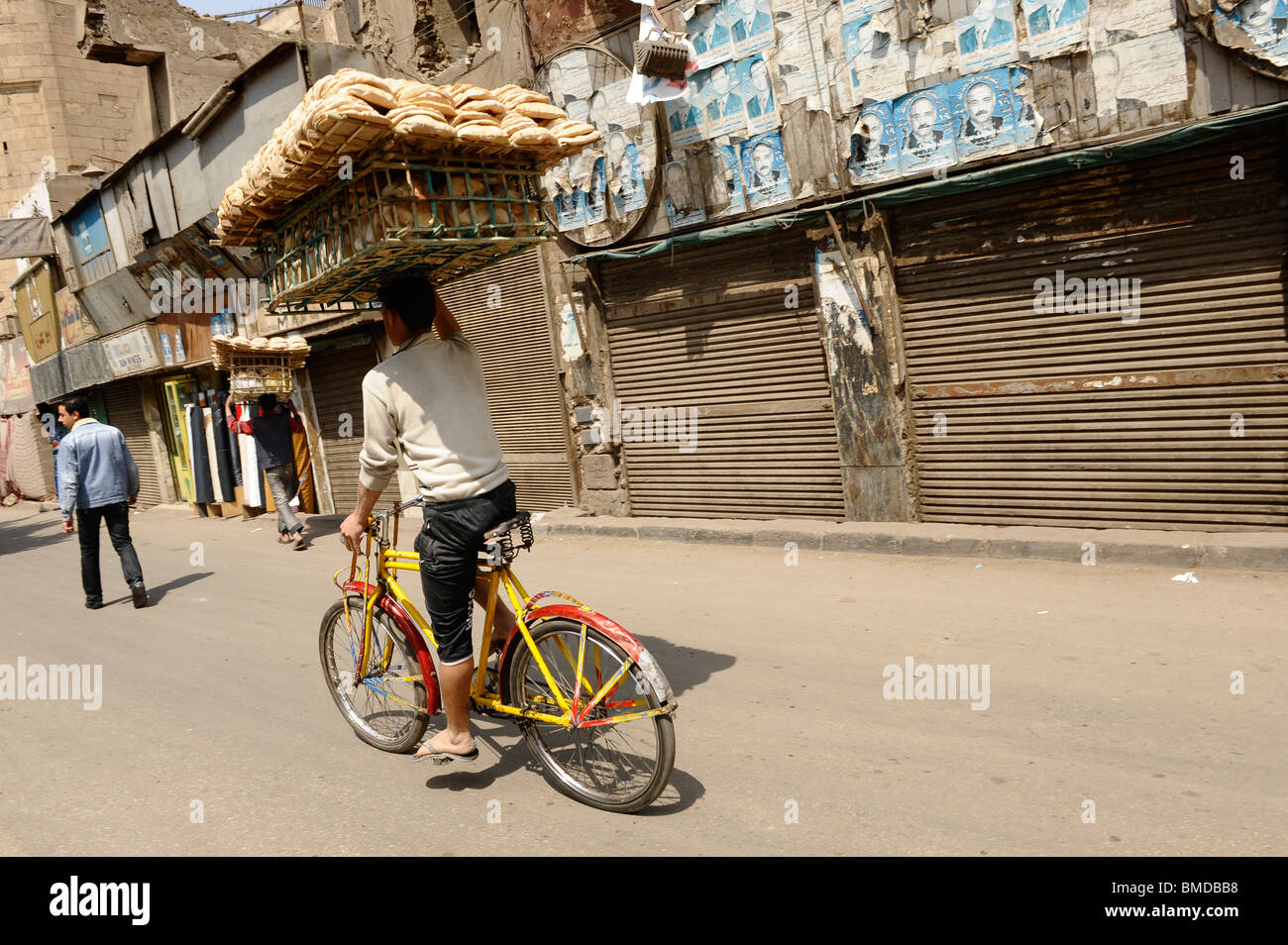 El hombre lleva el pan en la cabeza mientras viajaba en una bicicleta en El  Cairo islámico, Egipto Fotografía de stock - Alamy