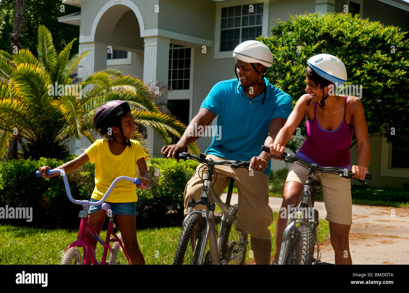 Roca Precursor Parecer Familia americana africana negra la enseñanza de su hija de 6 años de  correr en bicicleta en casa cochera Fotografía de stock - Alamy
