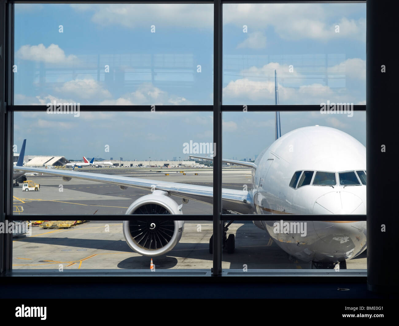 Los aviones estacionados en el aeropuerto a través de la puerta ventana. Foto de stock