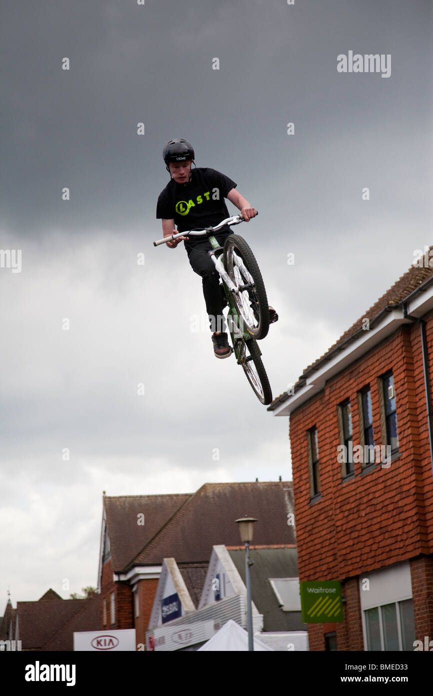 Un ciclista de BMX gana altura máxima durante una acrobacia mostrar, Haslemere, Surrey, Inglaterra. Foto de stock