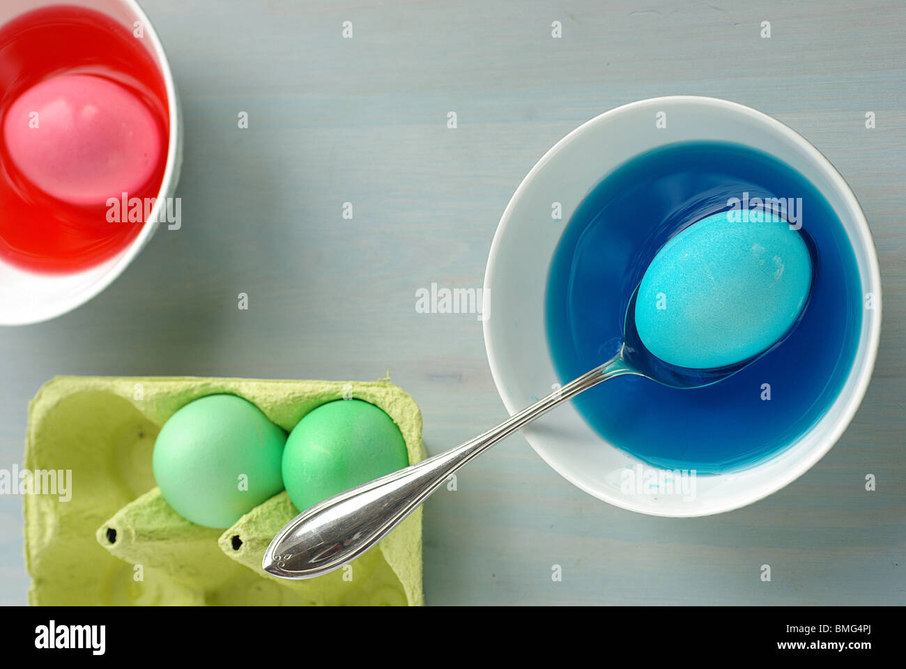 Huevos de Pascua está teñido en varios tazones de tintes de colores brillantes, Vertical Foto de stock