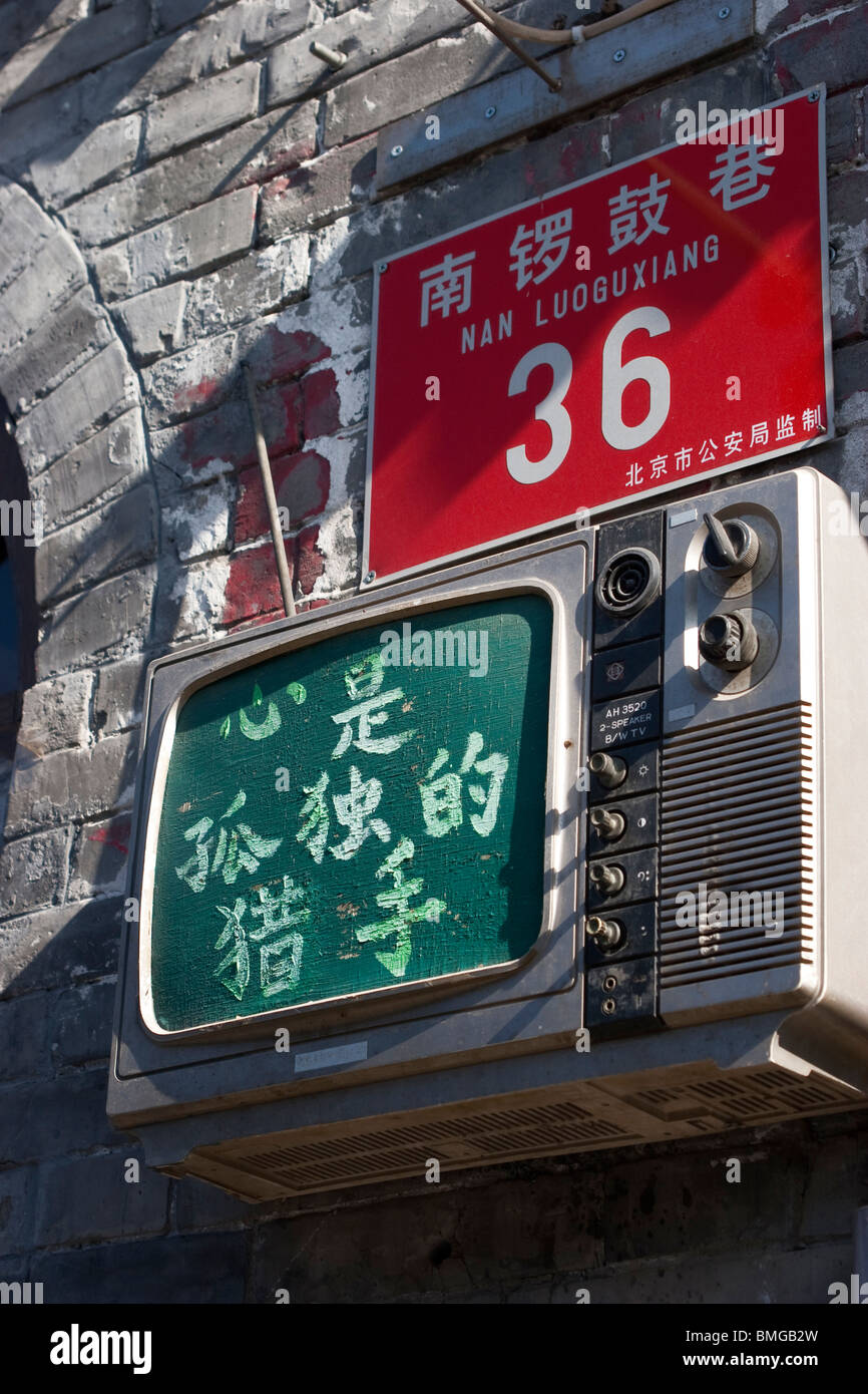 Muro de ladrillo decorado con la vieja estación de televisión, la calle Nanluoguxiang, Beijing, China Foto de stock