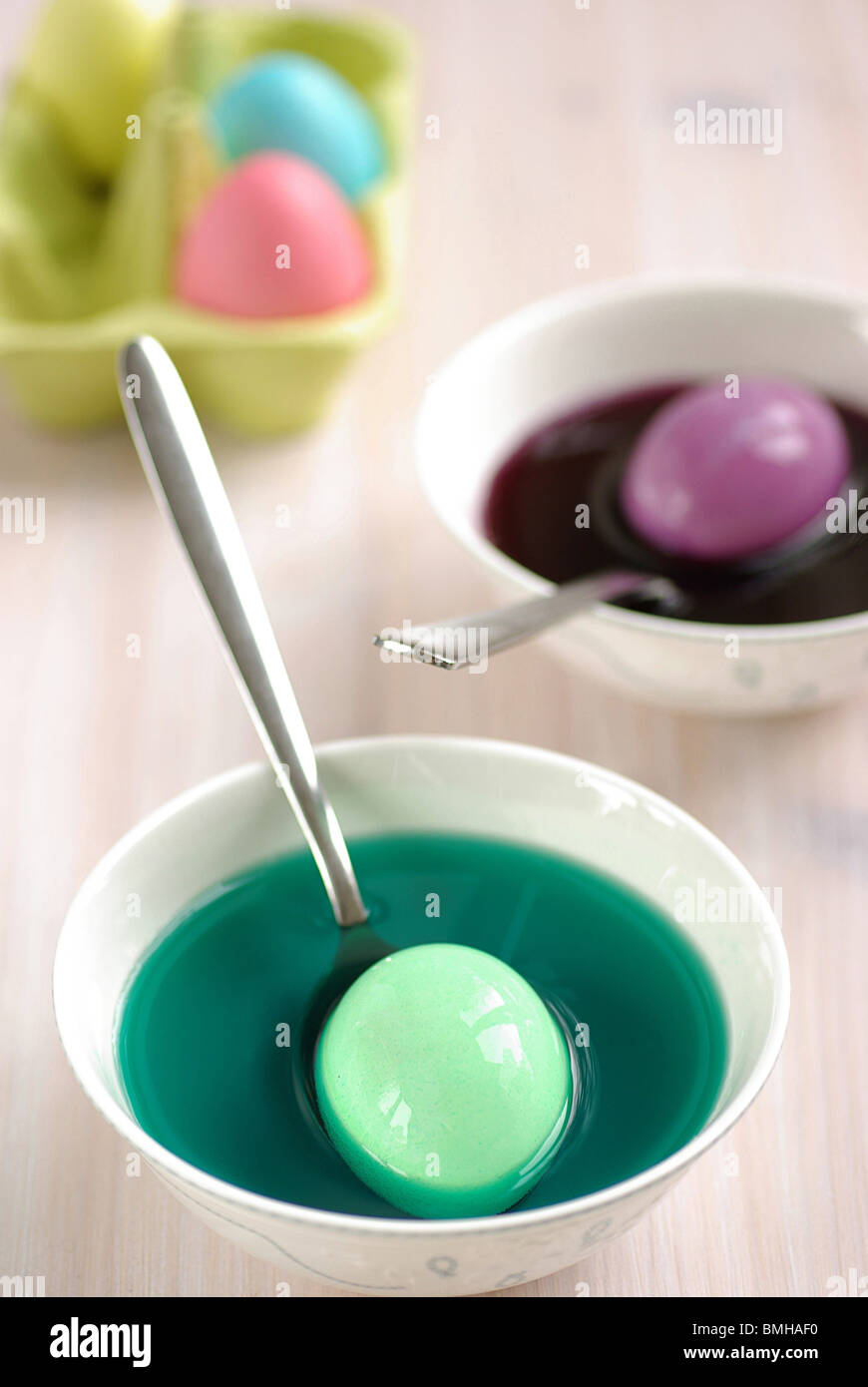 Huevos de Pascua está teñido en varios tazones de tintes de colores brillantes Foto de stock