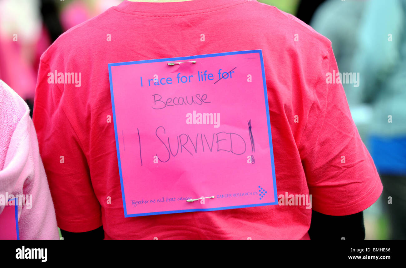 Los mensajes sobre las espaldas de las mujeres que toman parte en la investigación del cáncer carrera por la vida evento en Crawley Foto de stock