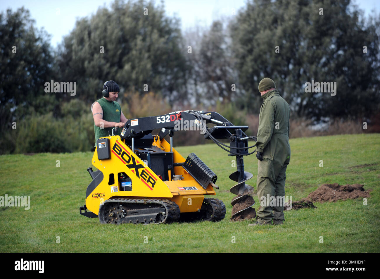 Un consejo trabajador usa un poder boxer excavadora para excavar agujeros para los árboles para las ciudades proyecto en Brighton Foto de stock