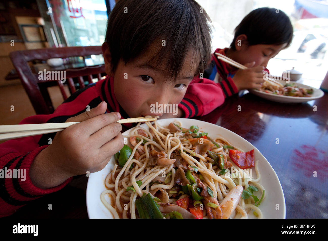 Hermanos comiendo fideos en Shigatse, Tibet Foto de stock