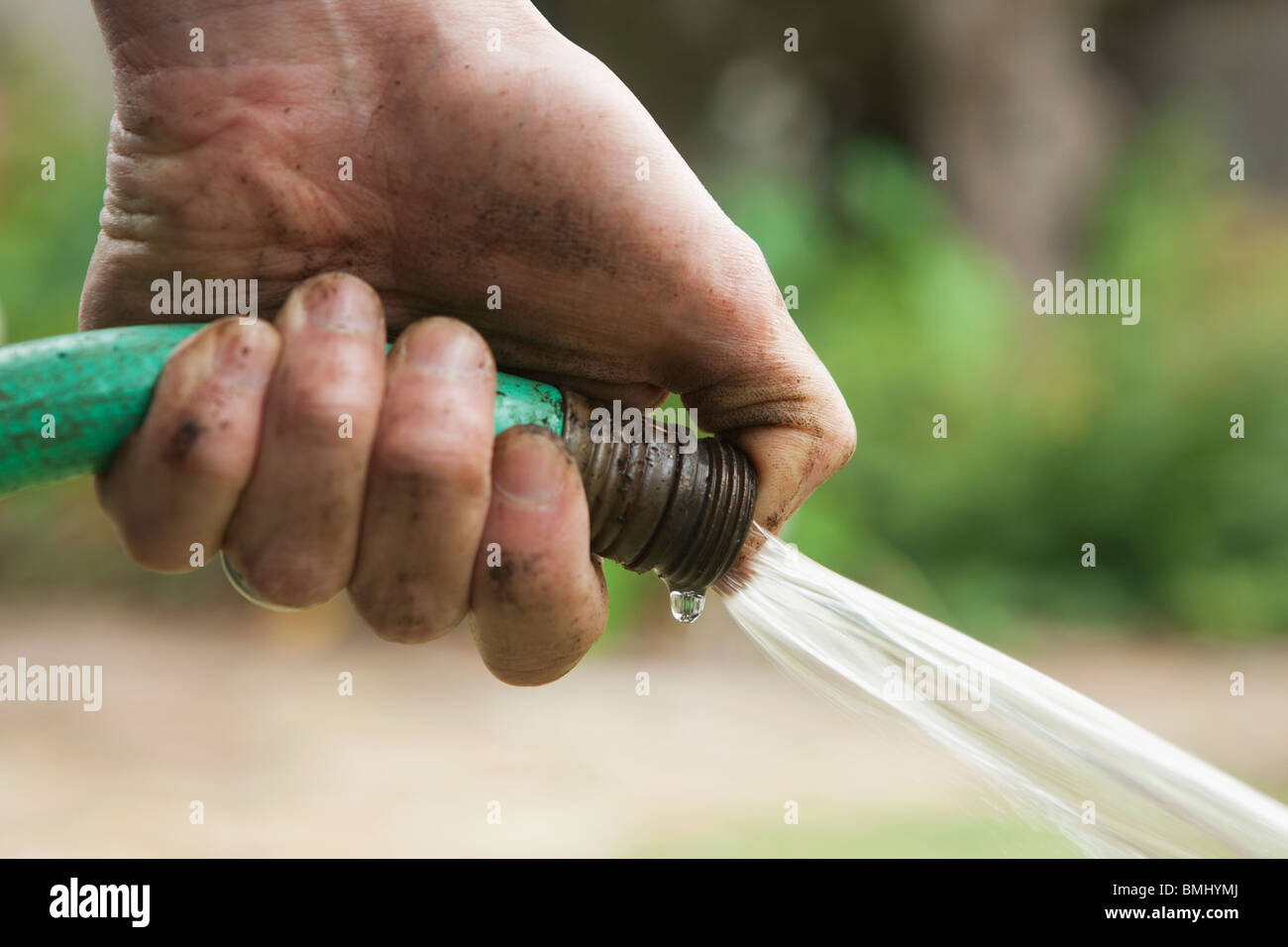 La mano que sujeta la manguera Fotografía de stock - Alamy