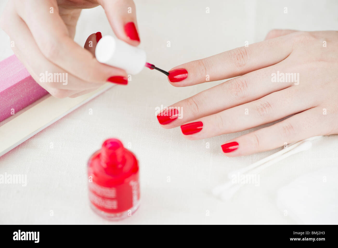 Mujer pintar sus uñas con esmalte de uñas de color rojo Foto de stock