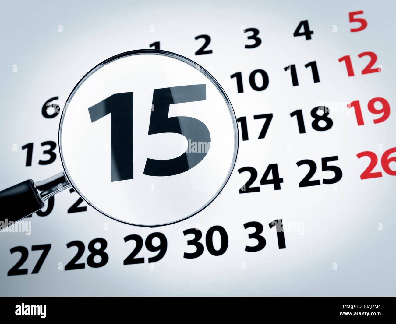 Una lupa en el decimoquinto día de una página del calendario. Foto de stock