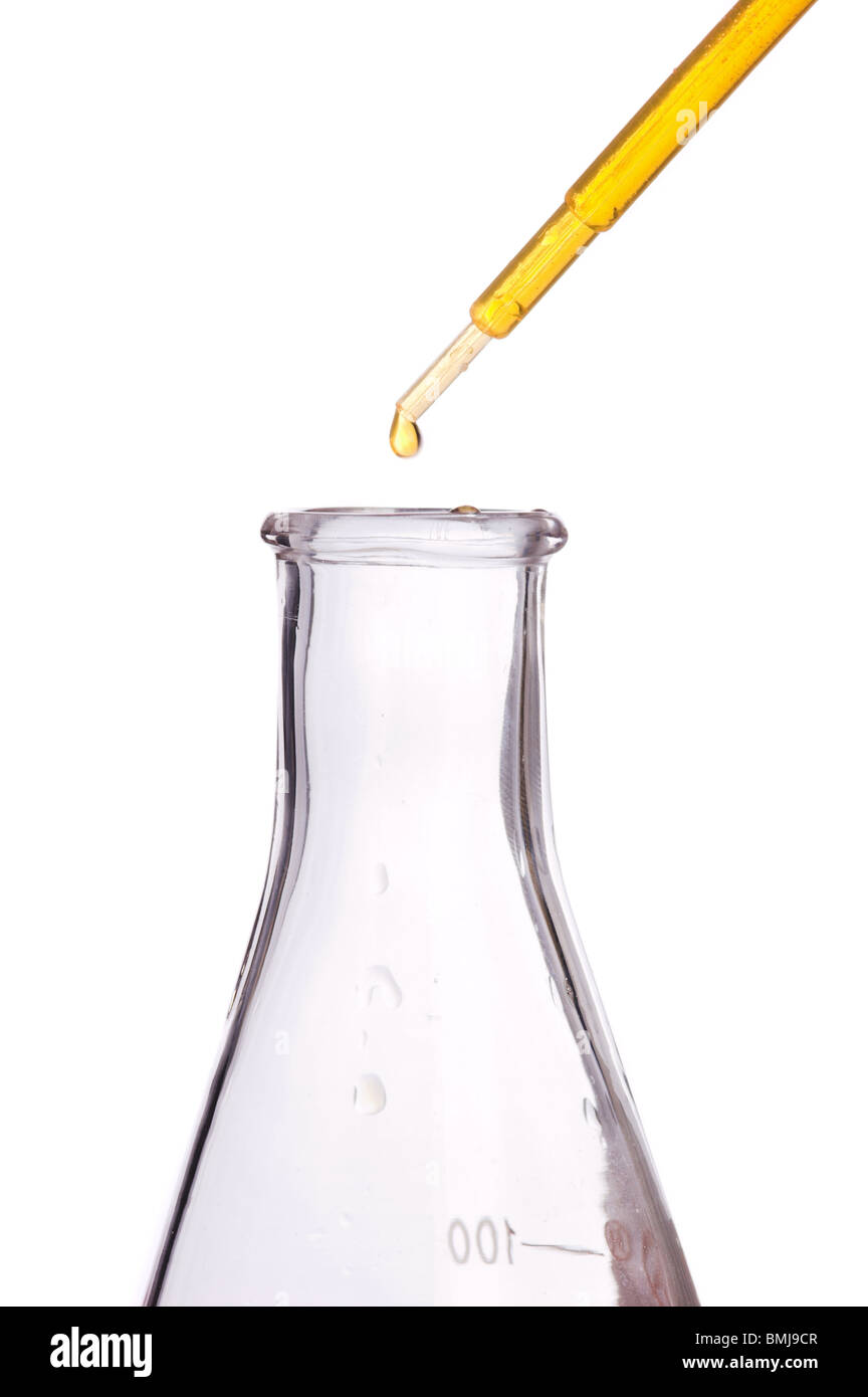 Pipeta con líquido amarillo sobre un matraz científico Foto de stock