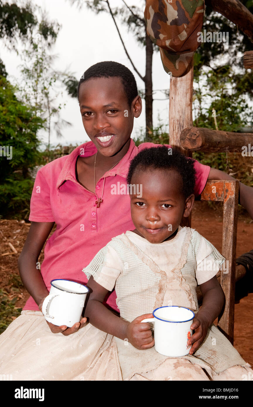 Par de hermanas disfrutando de una bebida a base de leche. Rwanda. Foto de stock