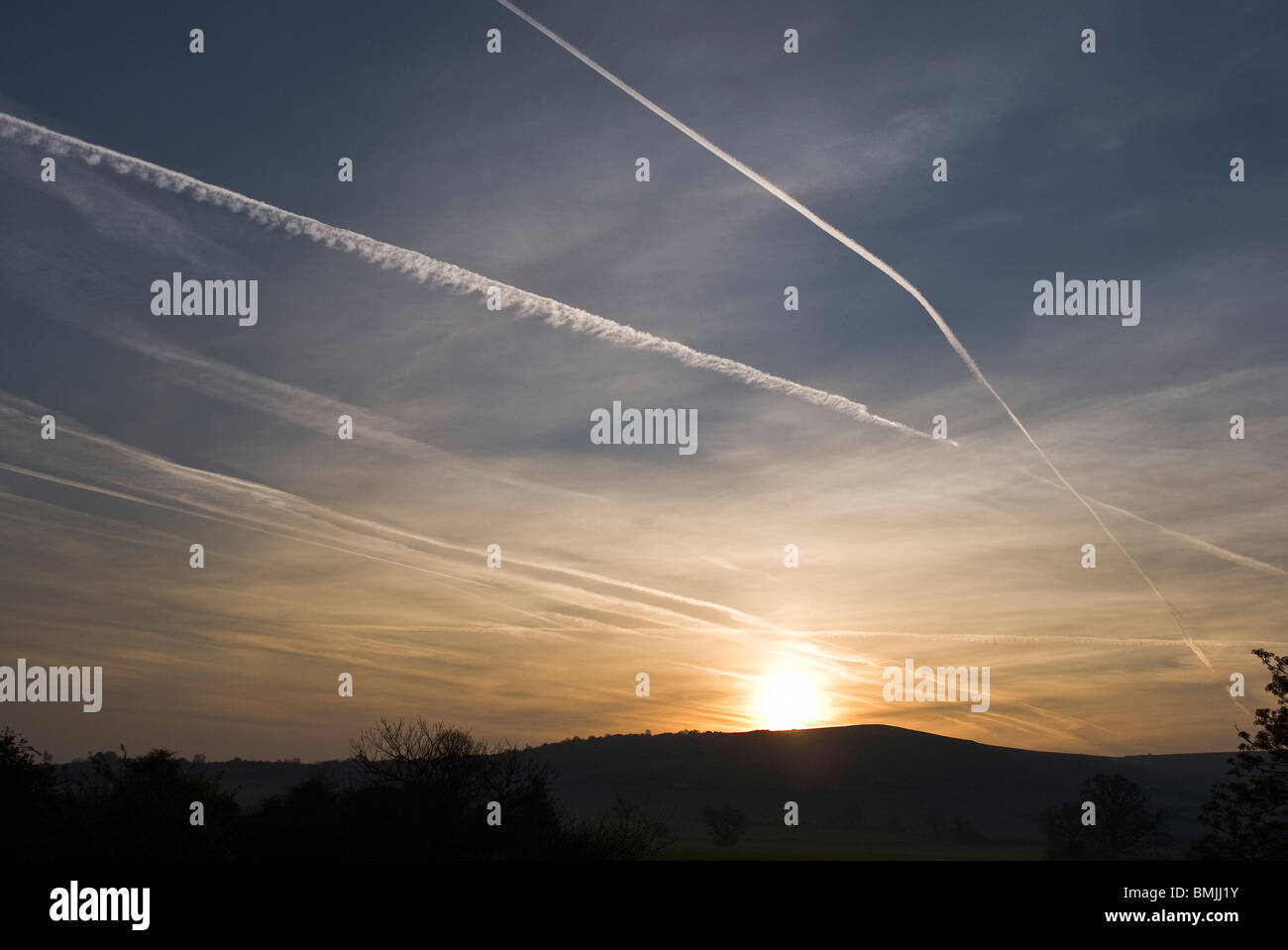 Las estelas de condensación de los aviones en el cielo del amanecer son vistos a través de ventanas de doble acristalamiento Foto de stock