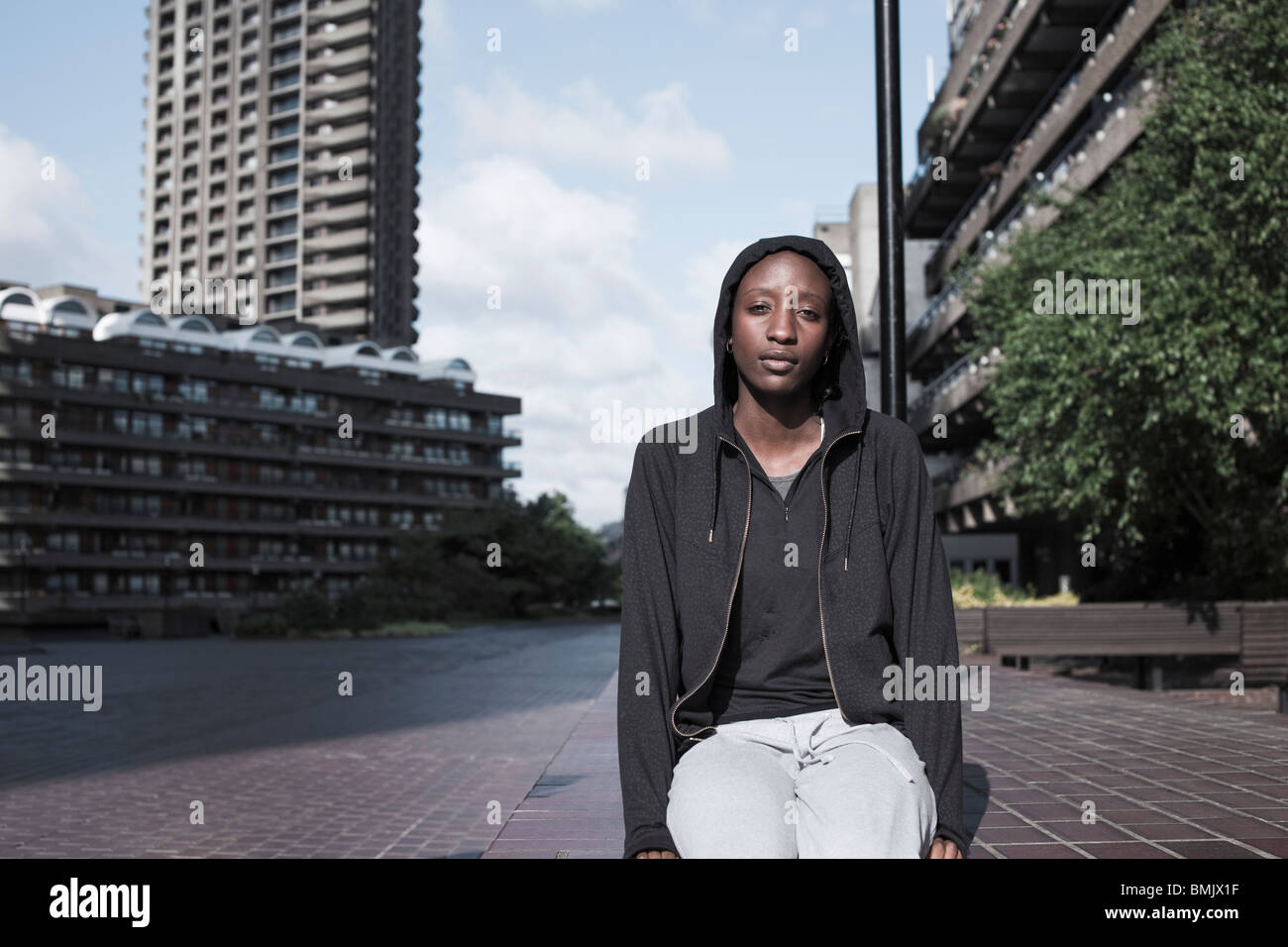Retrato de una mujer joven se sentaba fuera de la ciudad en la urbanización. Foto de stock