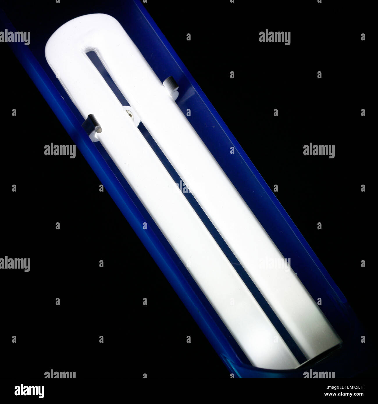 Un pequeño tubo fluorescente en una lámpara de escritorio Foto de stock