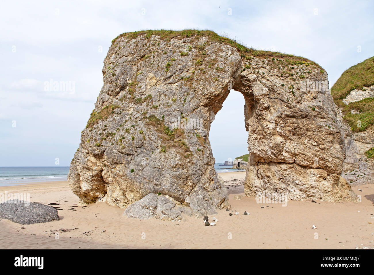 Arco natural en una playa de arena cerca de Portrush, Co. de Antrim, Irlanda del Norte Foto de stock