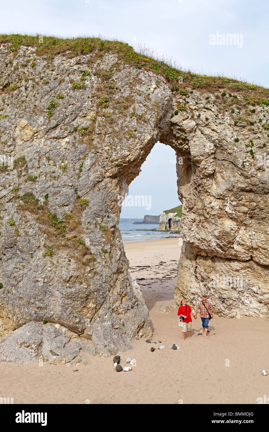 Arco natural en una playa de arena cerca de Portrush, Co. de Antrim, Irlanda del Norte Foto de stock