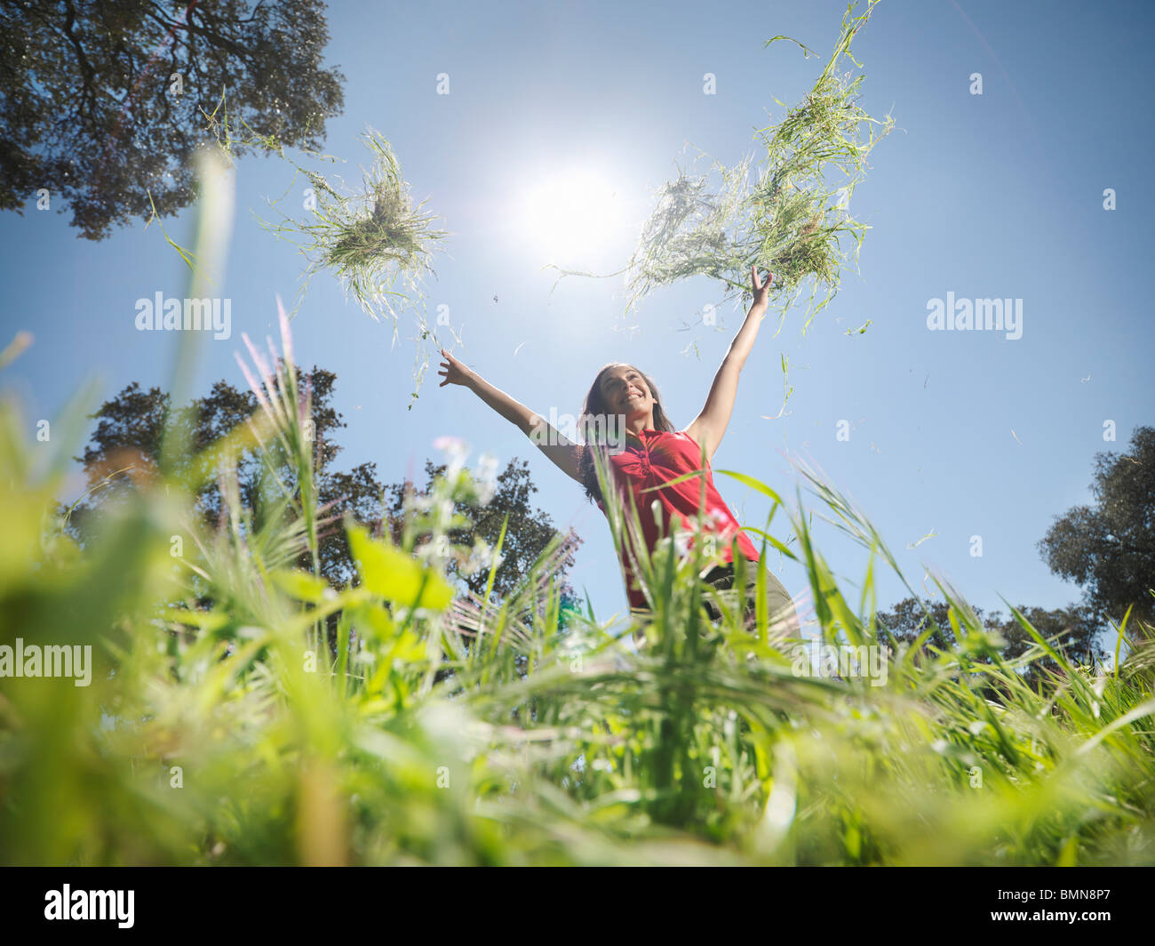 Mujer arrojando hierba en el aire Foto de stock