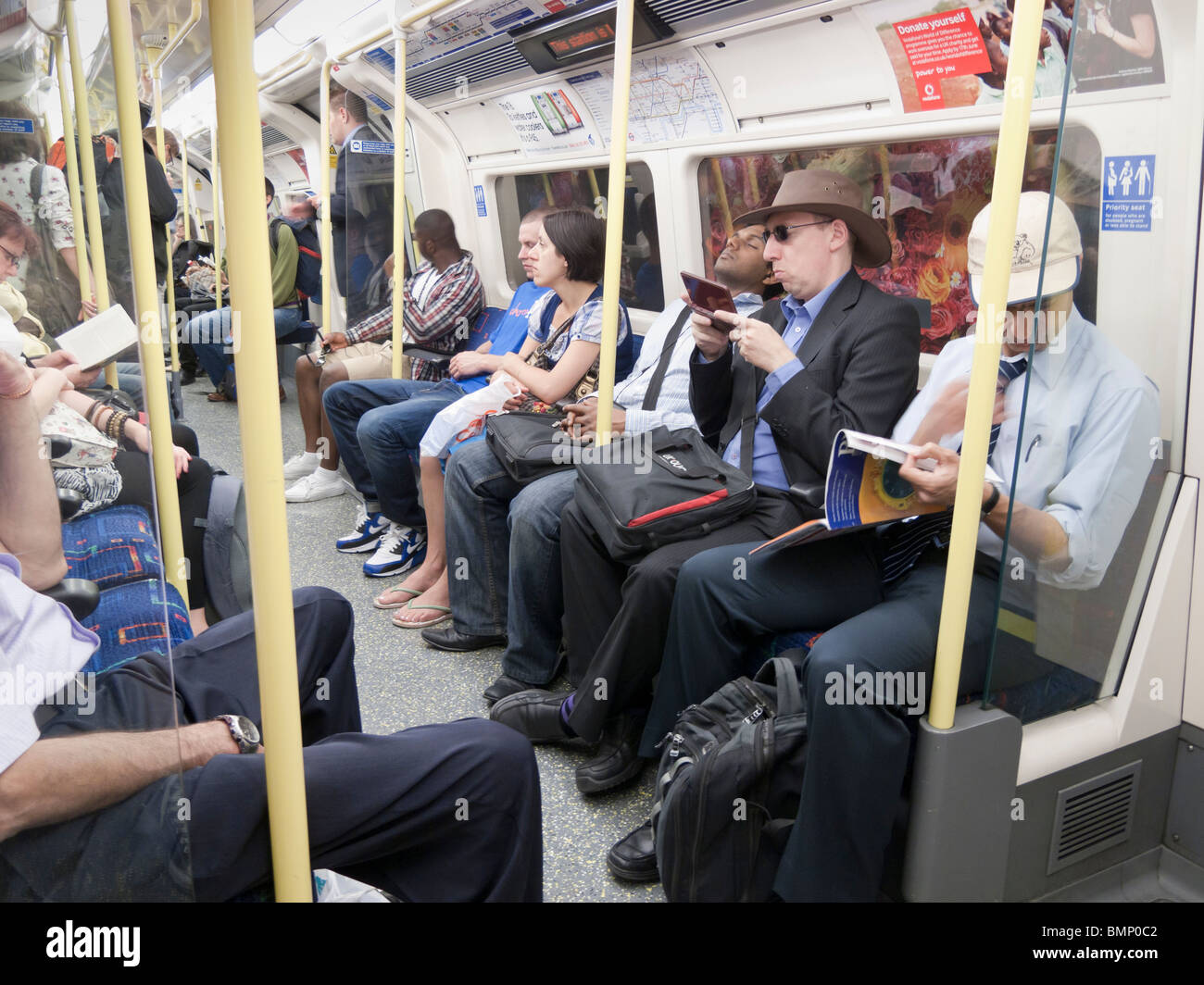 Personas en el tren subterráneo de Londres, Londres, UK Foto de stock