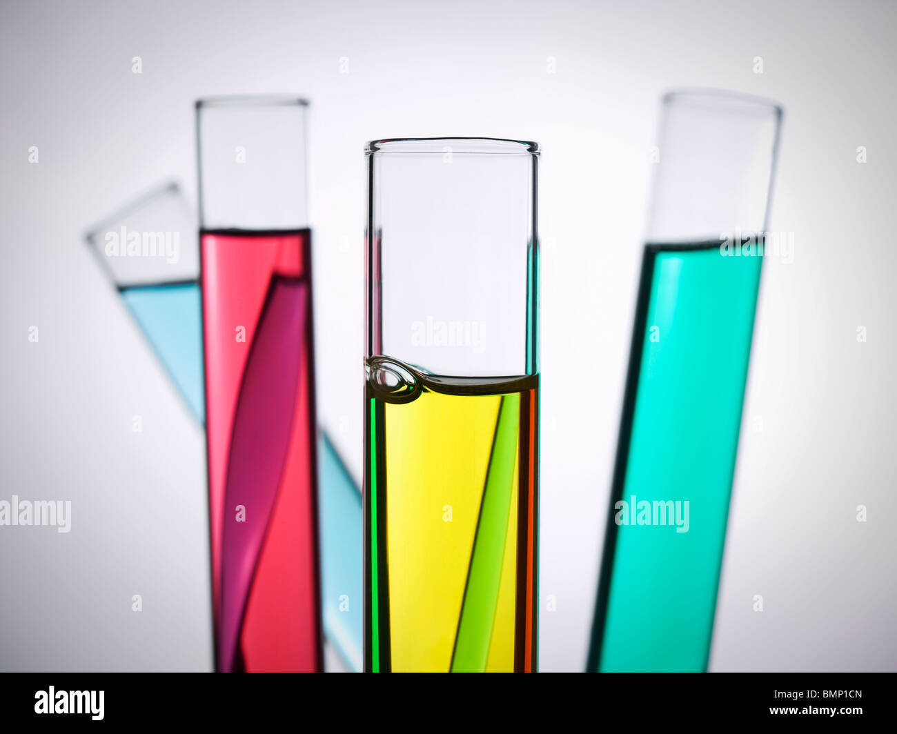 Cuatro tubos de ensayo llenos de líquidos de colores. Foto de stock