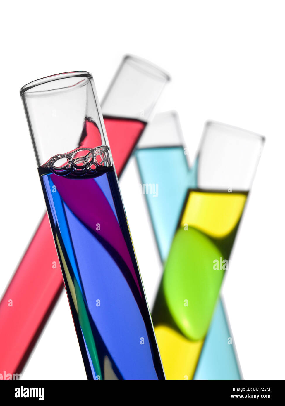Cuatro tubos de ensayo llenos de líquidos de colores. Aislado en blanco. Foto de stock