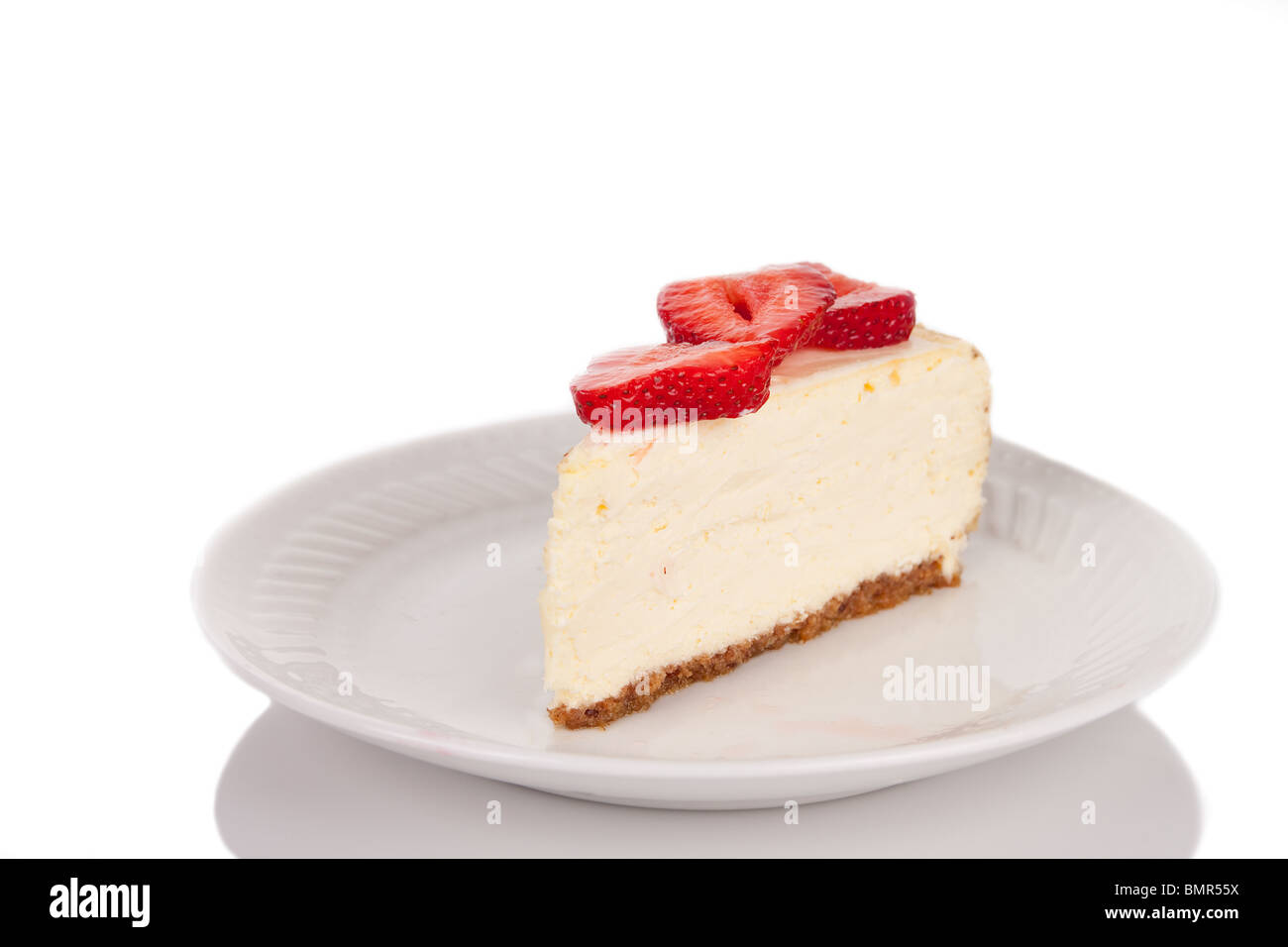 Una rebanada de Strawberry Cheesecake sobre una placa blanca. Foto de stock