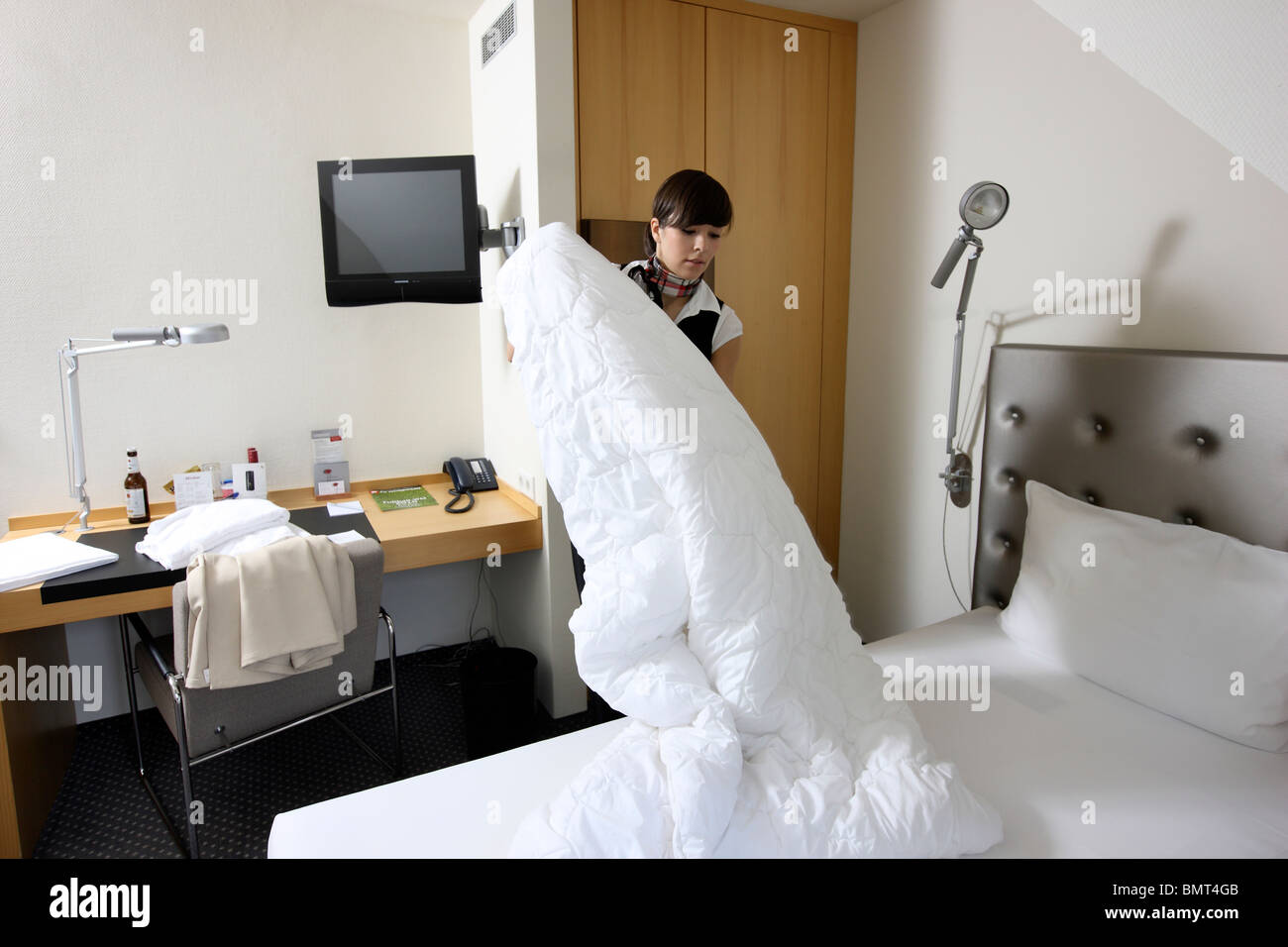 Hotel, servicio de habitaciones, limpieza y mantenimiento de la casa al trabajo en una habitación de hotel. hacer las camas de stock - Alamy