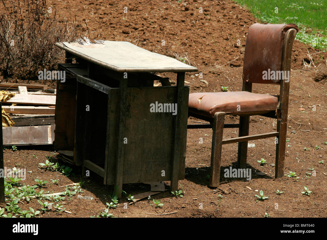 Mesa y silla artificiales en etapa rota dispuestos en la naturaleza Foto de stock